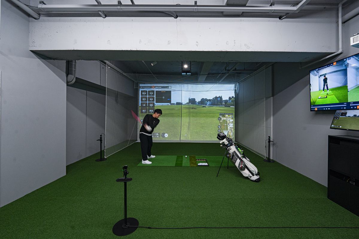 VIPスペースでTrackManのスクリーンに向かってスイングする人
